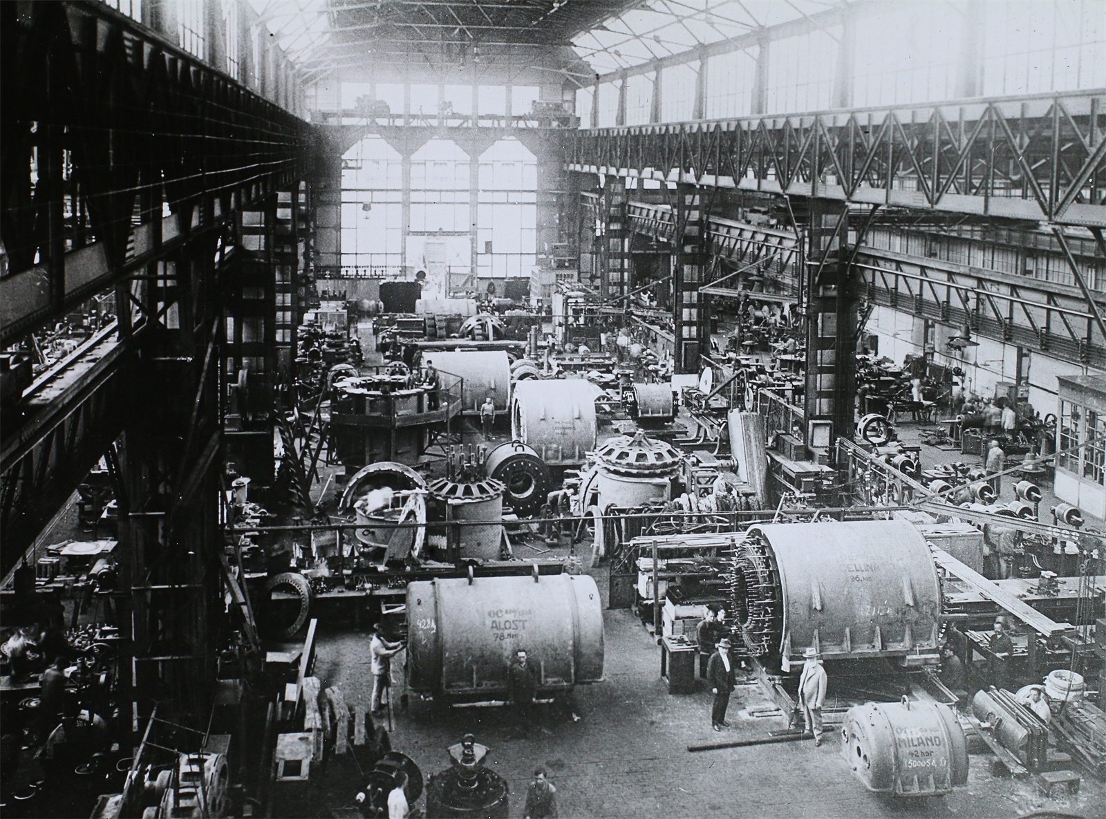 Historic photograph of a large engineering works hall with generators being assembled